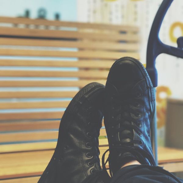Man in a seated meditation pose against a minimalist background.